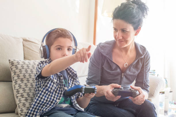 Mother and son playing on console with Videogames joystick